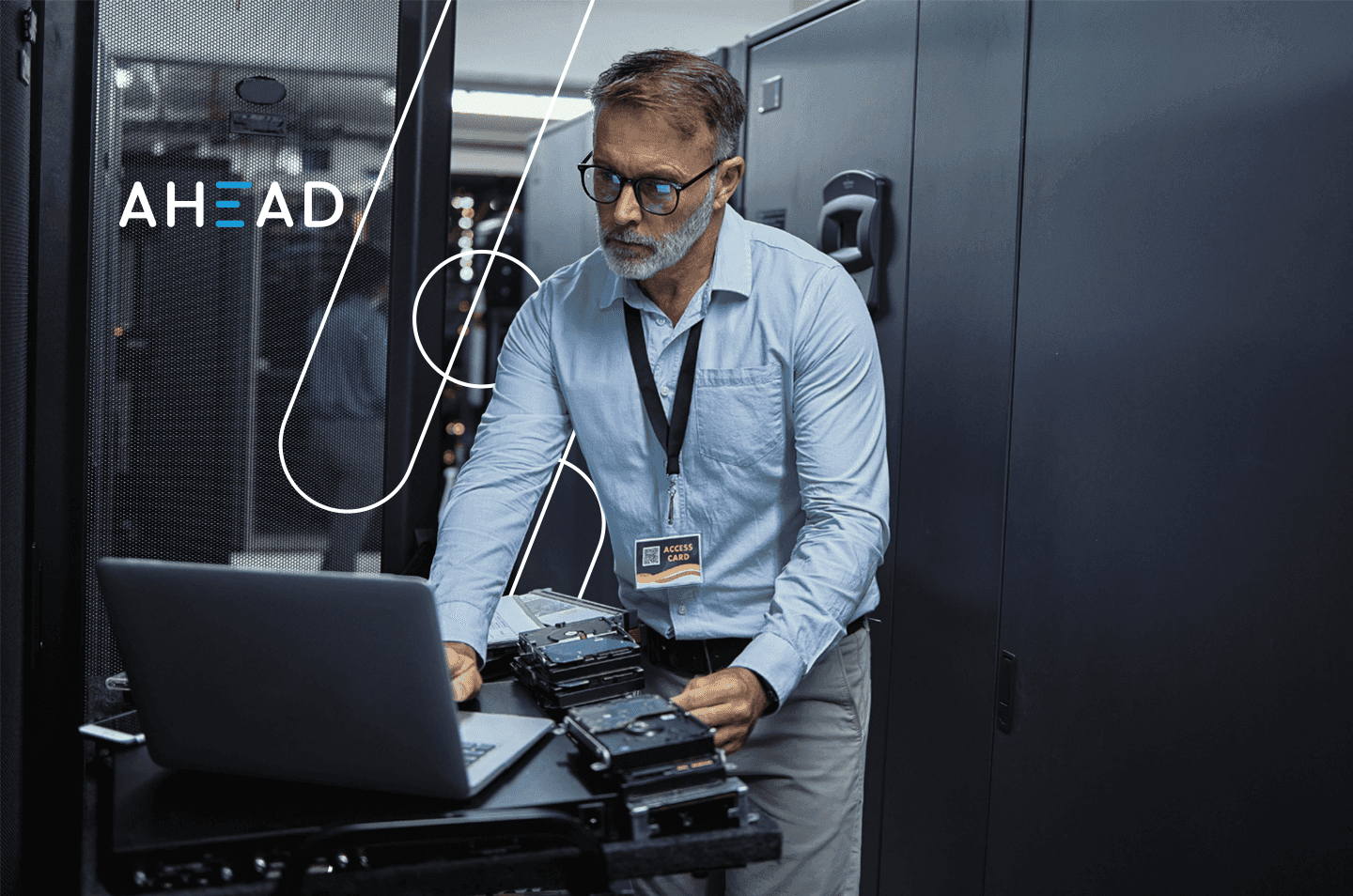 a man working on a laptop inside a data center