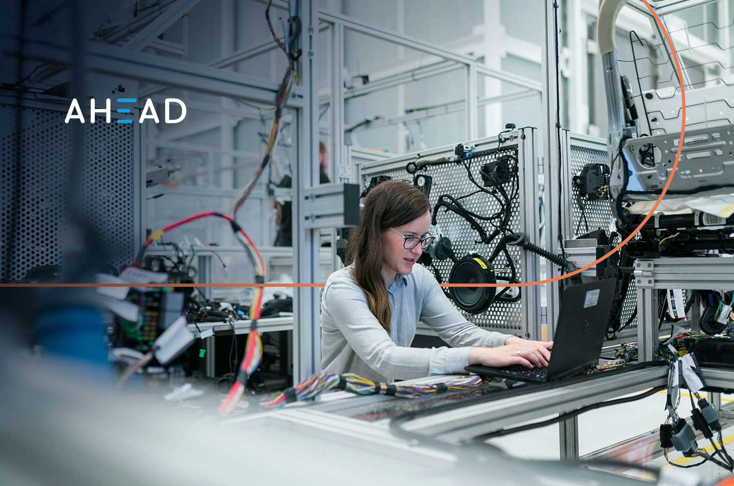 a woman sitting in a lab surrounded by mechanical components